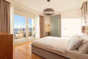 a bedroom with a large bed and a large window at Villa Hedonism in Sveti Stefan