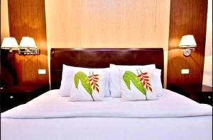 a bed with white sheets and pillows with christmas decorations at Lukay Las Brisas in Boracay