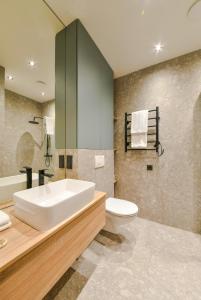 a bathroom with a tub and a toilet and a sink at Apartments near Ozas in Vilnius
