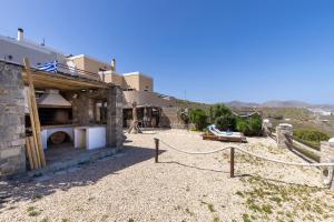 un edificio de piedra con un horno en un patio en Aegean View - Seaside Apartment in Syros, en Azolimnos