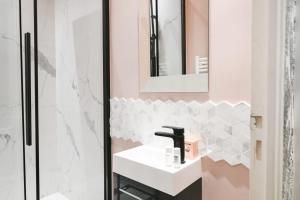 a bathroom with a sink and a mirror at Le Marais Pl de la Bastille 3BD 3BTH for 10 guests in Paris