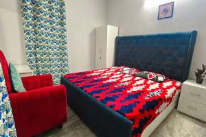 a bedroom with a blue bed and a red chair at work stay enjoy outdoor party in Faridabad