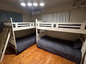 two bunk beds in a room with wooden floors at ホロホロバイライフタイム in Furugen
