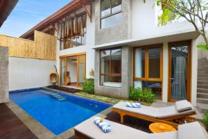 een huis met een zwembad ervoor bij Kamalini 2 BR Private Pool Villa With Bathtub ZN68 in Canggu