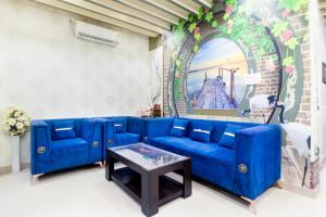 a blue couch in a living room with a table at Treebo Royal Imperial, Bikaner Railway Station in Bikaner