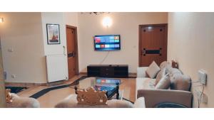 een woonkamer met banken en een tv bij Family Apart ISB F-11 #5 in Islamabad