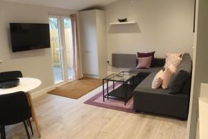 a living room with a couch and a table at The Garden Cabin in Reading