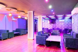 比卡內爾的住宿－Treebo Trend Royal Imperial With Roof Top Cafe，配有桌椅和紫色照明的房间