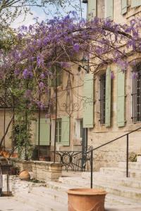 un edificio con un albero con fiori viola di Auberge de la Treille - Chambres d'Hôtes ad Avignone