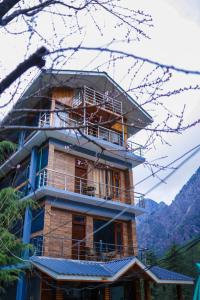 a tall building with a balcony on top of it at Forest View by The Delhi Heights Kasol in Kasol