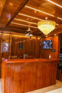 a bar in a restaurant with a chandelier at Forest View by The Delhi Heights Kasol in Kasol