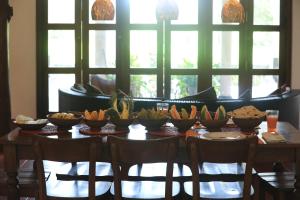 a table with bowls of fruits and vegetables on it at Kumbura Homestay in Sigiriya