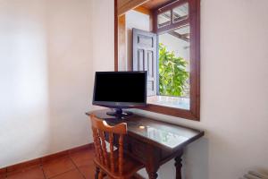 un monitor de ordenador sentado en un escritorio frente a un espejo en Casa La Podona- A, en Jedey