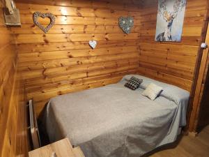 1 dormitorio con 1 cama en una pared de madera en Cabaña los chorros en Riópar