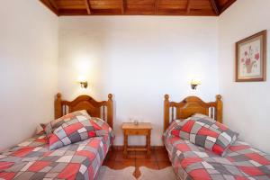 1 dormitorio con 2 camas y mesa auxiliar en Casa La Podona- A, en Jedey