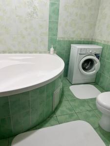 a bathroom with a tub and a washing machine at ИП.МЕДИНА in Taraz +5 photos
