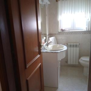 uma casa de banho com um lavatrio, um WC e uma porta em Terra Mista Alojamento Local em Gouveia