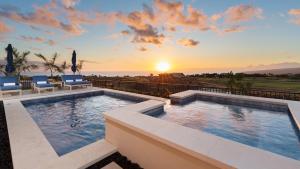 una piscina con puesta de sol en el fondo en BLUE TRANQUILITY Luxurious home in private community with Heated Private Pool Spa Detached Ohana Suite, en Waimea