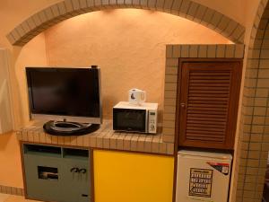 una cucina con TV e forno a microonde di ホテル　プレリュード a Iwakiri