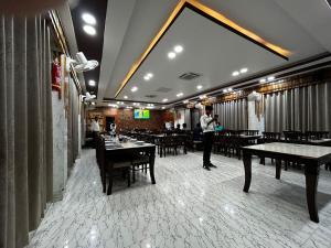 a person standing in a restaurant with tables and chairs at The Heritage in Dumka