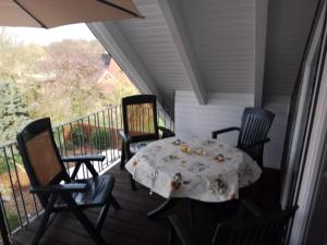 een veranda met een tafel en stoelen op een balkon bij Haus Meyne in Bad Fallingbostel