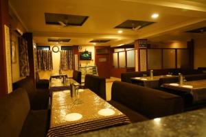 een restaurant met tafels en banken in een kamer bij Hotel Shubh Shree Bilaspur in Bilāspur