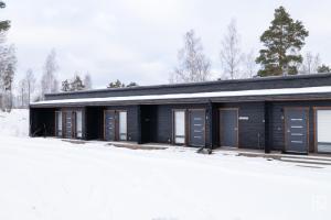 a building with a lot of windows in the snow at Ellivuori Chalet Moisio in Sastamala