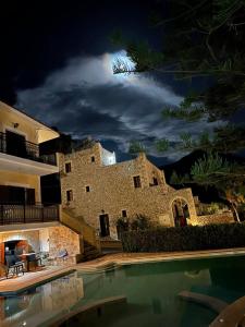 a night view of a building with a swimming pool at LITHOS by the sea in Neon Oitilon