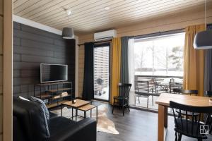 a living room with a couch and a table with a television at Ellivuori Chalet Moisio in Sastamala