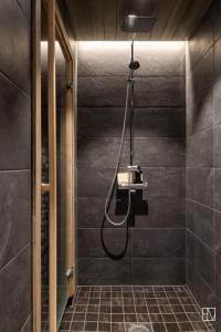 La salle de bains est pourvue d'une douche avec un pommeau de douche. dans l'établissement Ellivuori Chalet Moisio, à Sastamala