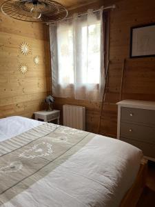um quarto com uma cama grande e uma janela em 40m2 au pied des pistes Hauteluce les saisies 4 à 6 personnes em Hauteluce
