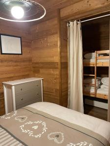 um quarto com uma cama num chalé de madeira em 40m2 au pied des pistes Hauteluce les saisies 4 à 6 personnes em Hauteluce
