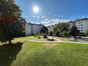 un parque con un banco en el césped en StayRoom Apartments I "Woody5" neben Donaulände en Linz