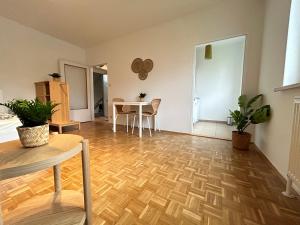 sala de estar con suelo de madera y mesa en StayRoom Apartments I "Woody5" neben Donaulände en Linz