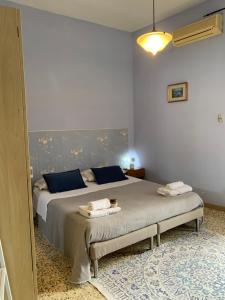a bedroom with a large bed with blue pillows at Luna Piena B&B in Lecce