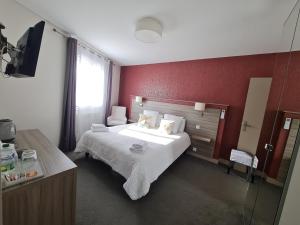 a bedroom with a bed and a red wall at Logis Hôtel Restaurant Clair Cottage, Chisseaux - Chenonceaux in Chisseaux