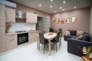 eine Küche und ein Wohnzimmer mit einem Tisch und einem Sofa in der Unterkunft Villa Marchese in Trecastagni