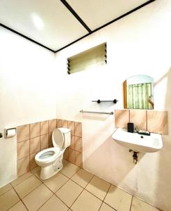 a bathroom with a toilet and a sink at Green Garden Beach Resort, Sipalay in Sipalay