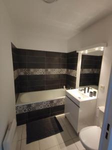 uma casa de banho com uma banheira, um WC e um lavatório. em Agde Studio proche Plage em Agde