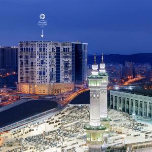 - une vue sur une ville avec une tour de l'horloge la nuit dans l'établissement Anjum Makkah Hotel, à La Mecque