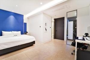 a bedroom with a bed and a desk and a computer at Hotel Zam 101 in Busan +64 photos