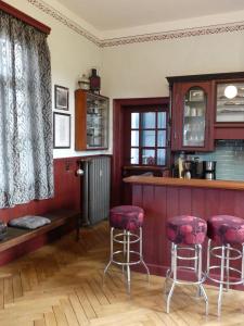 eine Küche mit einer Bar mit roten Stühlen in der Unterkunft Ferienwohnung Bahnhof 1892 in Meeder