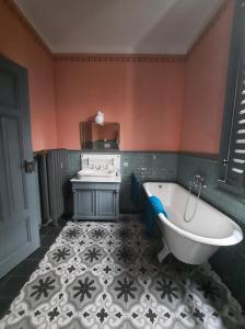 ein Badezimmer mit einer Badewanne und einem Waschbecken in der Unterkunft Ferienwohnung Bahnhof 1892 in Meeder