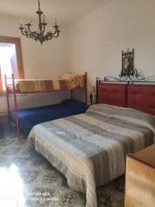 een slaapkamer met 2 bedden en een kroonluchter bij Oasi dell' Etna in Piedimonte Etneo