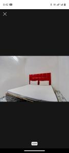 - une chambre avec un lit à tête rouge dans l'établissement VR HOTEL, à Auraiya