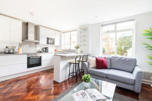a kitchen and living room with a couch and a table at Marylebone - Wimpole Street - CityApartmentStay in London