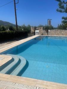 uma grande piscina com azulejos azuis em LITHOS by the sea em Neon Oitilon