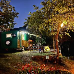 a green trailer parked in front of a tent at UCM Adventure Park in San Mateo