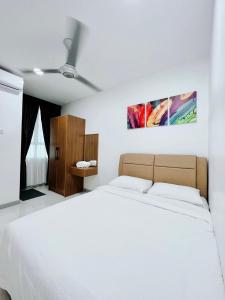 a bedroom with a white bed and a wooden cabinet at D'CIELLA Homes- Sea View, Drawbridge & KTCC Mall in Kuala Terengganu