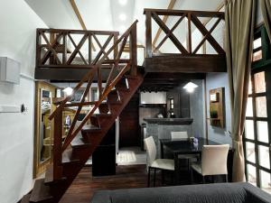 eine Treppe in einem Zimmer mit einem Tisch und einer Küche in der Unterkunft Old Klang Road Homestay Dungun in Dungun